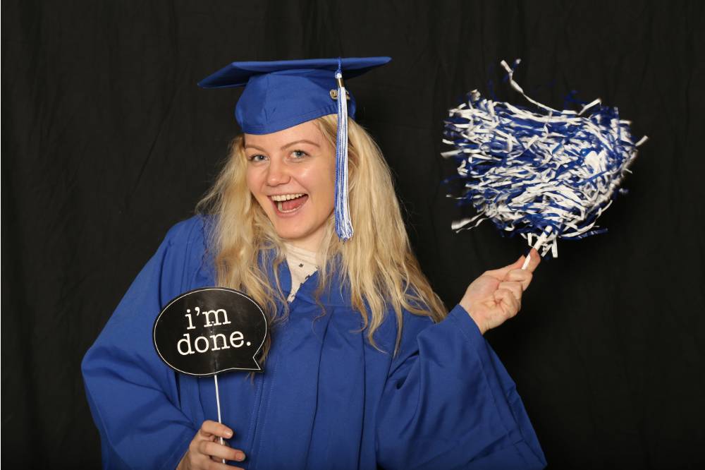 soon to be graduate takes a fun picture with photo booth props